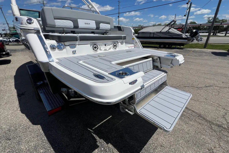 Slide: The Image of 2026 Chaparral SSX 6 boat with spacious swim platform and seating, parked outdoors. - 15