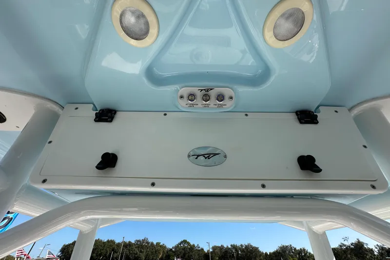 Slide: The Image of 2023 Tidewater 210 CC Adventure boat with T-top, parked outdoors under blue sky. - 18