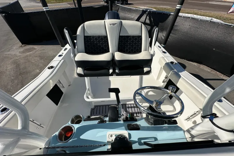 Slide: The Image of 2023 Tidewater 210 CC Adventure boat dashboard with steering wheel and controls. - 27