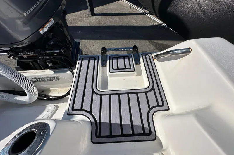 Slide: The Image of 2023 Tidewater 210 CC Adventure boat interior with white seating and speakers. - 37