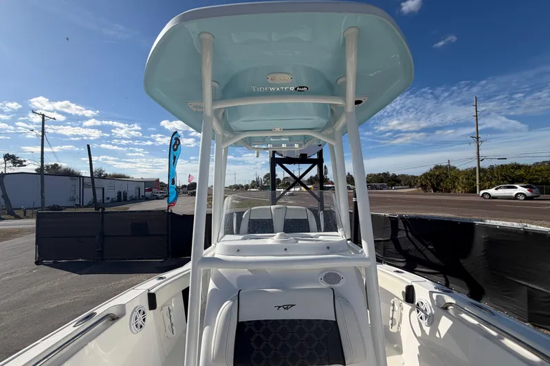 Slide: The Image of 2023 Tidewater 210 CC Adventure boat with T-top, parked outdoors under a clear blue sky. - 54