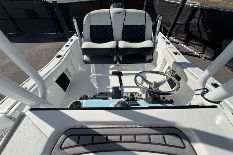 Slide: The Image of 2023 Tidewater 210 CC Adventure boat cockpit with steering wheel and seating. - 55