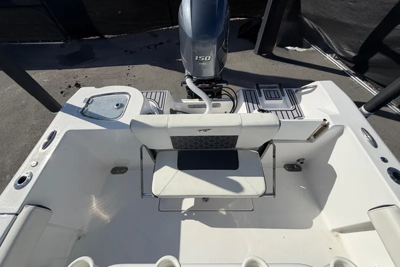 Slide: The Image of 2023 Tidewater 210 CC Adventure boat interior with seating and engine view. - 58