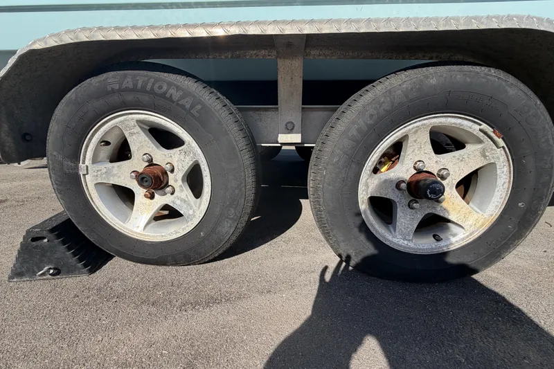 Slide: The Image of Trailer wheels for 2023 Tidewater 210 CC Adventure boat on pavement. - 64