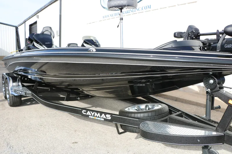 Slide: The Image of 2025 Caymas CX 21 PRO boat on trailer, sleek black design, parked outdoors. - 16