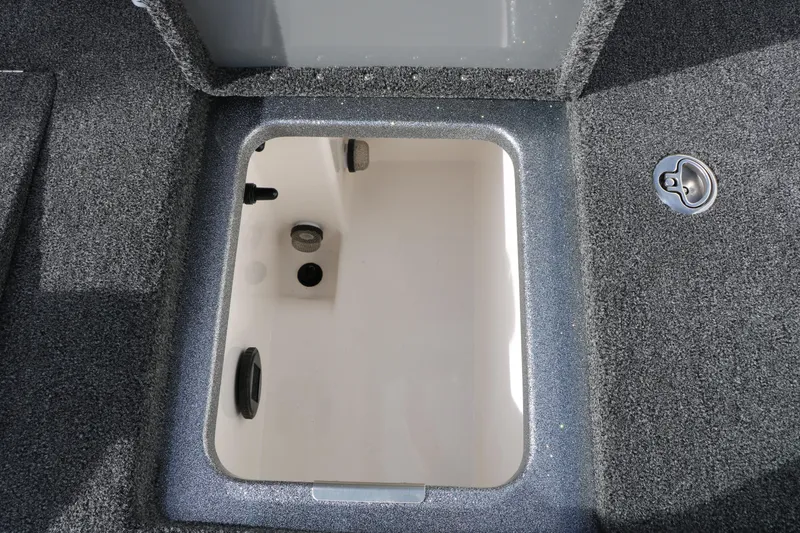 Slide: The Image of Open storage compartment in 2025 Caymas CX 21 PRO boat, featuring carpeted interior. - 36
