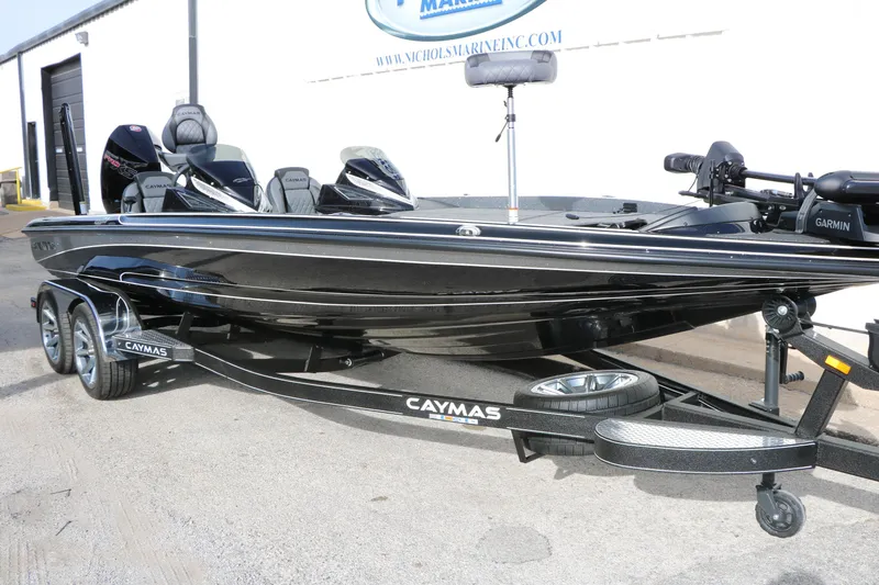 Slide: The Image of 2025 Caymas CX 21 PRO boat on trailer, sleek black design, parked outdoors. - 4