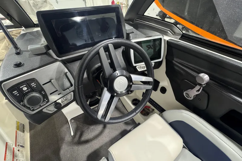 Slide: The Image of 2019 Malibu Wakesetter 21 MLX boat dashboard with steering wheel and control panels. - 14