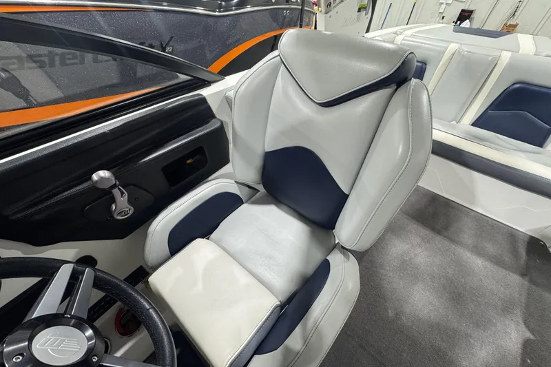 Slide: The Image of 2019 Malibu Wakesetter 21 MLX interior with gray and navy seating, steering wheel, and dashboard. - 15