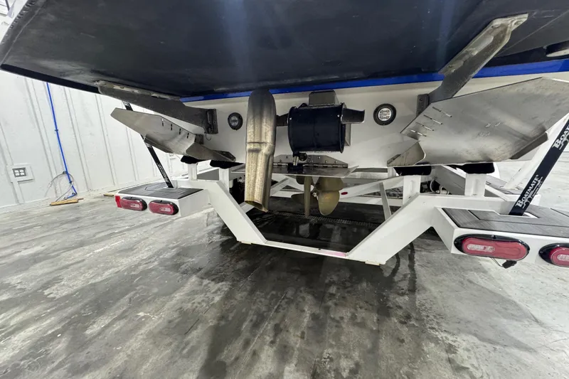 Slide: The Image of 2021 Tigé 25ZX boat in red and blue on a trailer inside a showroom. - 17