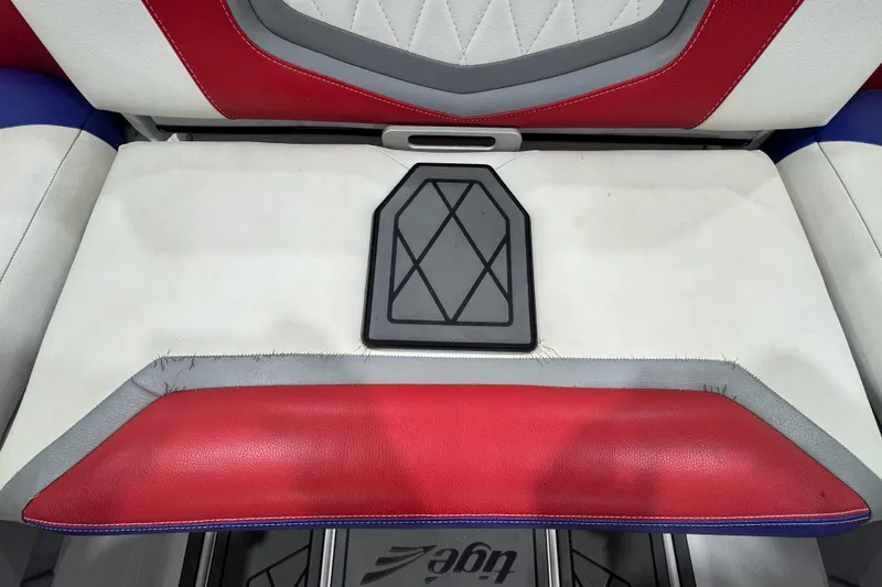 Slide: The Image of 2021 Tigé 25ZX boat interior with red, white, and blue seating and speaker system. - 25
