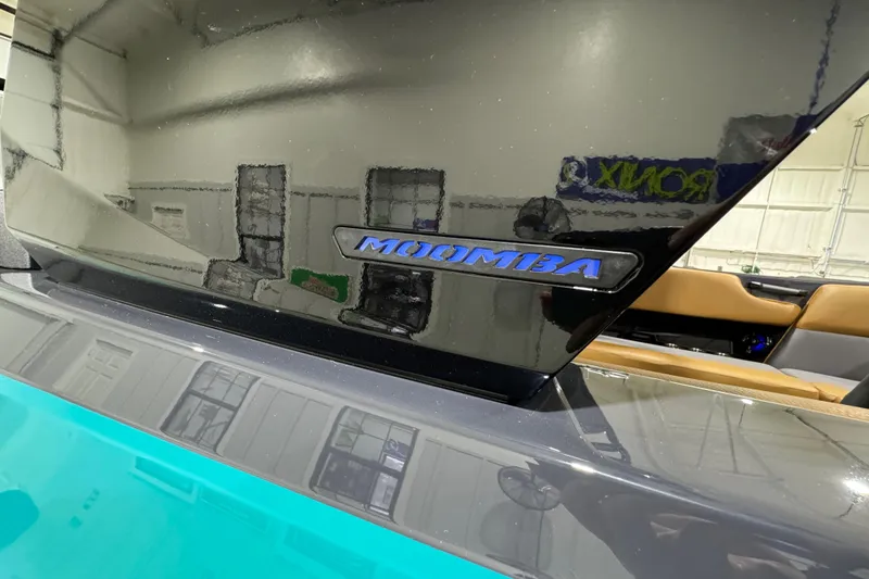 Slide: The Image of 2026 Moomba Tykon boat with sleek black and turquoise design. - 23
