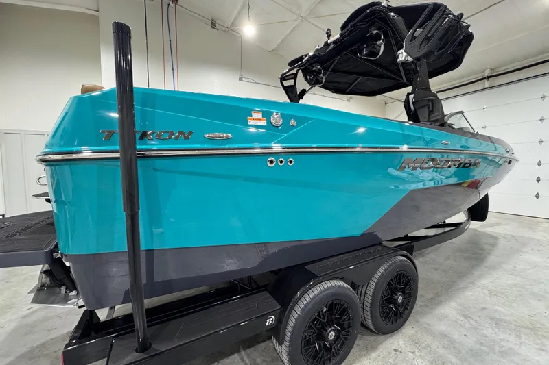 Slide: The Image of 2026 Moomba Tykon boat in a garage, featuring a sleek turquoise design. - 5