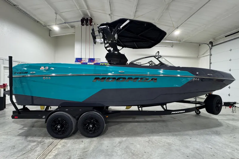 Slide: The Image of 2026 Moomba Tykon boat in a garage, featuring a sleek design and vibrant teal color. - 6