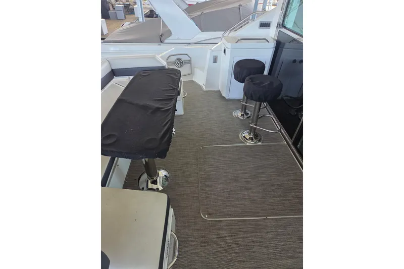 Slide: The Image of 2018 Cruisers Yachts 54 Cantius interior with covered seating and bar stools. - 24