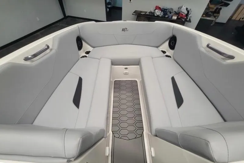 Slide: The Image of 2022 MasterCraft NXT24 boat interior with gray seating and hexagonal floor design. - 10