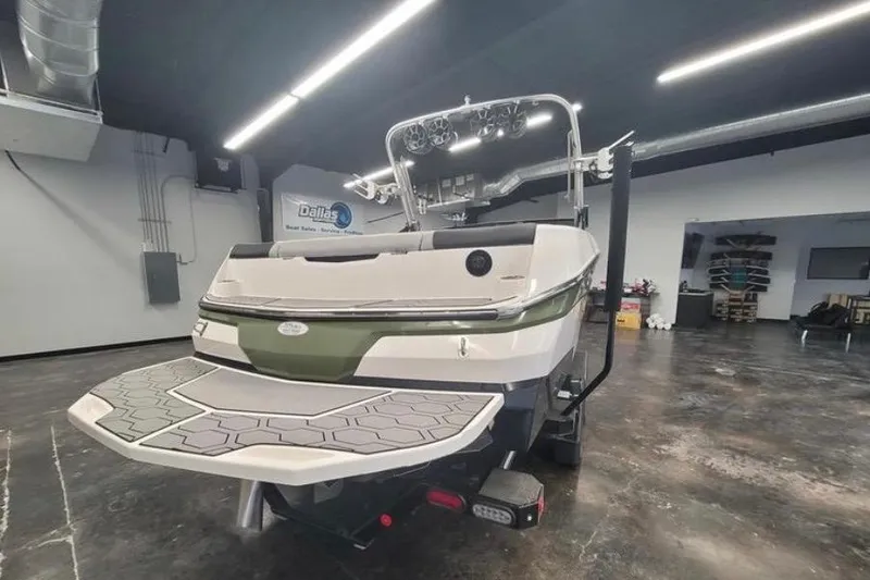 Slide: The Image of 2022 MasterCraft NXT24 boat in showroom, rear view with swim platform. - 3