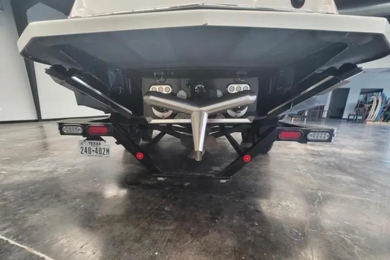 Slide: The Image of 2022 MasterCraft NXT24 boat rear view in a showroom, showcasing propeller and trailer. - 4