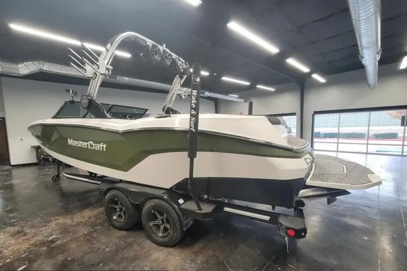Slide: The Image of 2022 MasterCraft NXT24 boat in showroom, featuring sleek design and dual-axle trailer. - 5