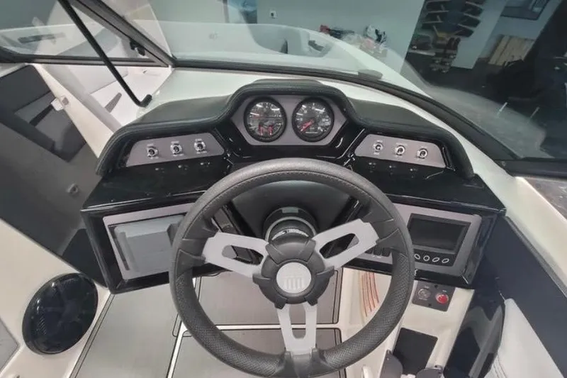 Slide: The Image of 2022 MasterCraft NXT24 boat dashboard with steering wheel and control gauges. - 8