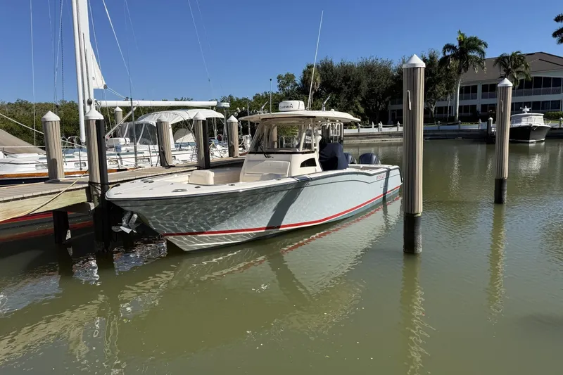 The Image of 2020 Grady-White Canyon 326 boat docked in a marina under clear blue skies. - 0