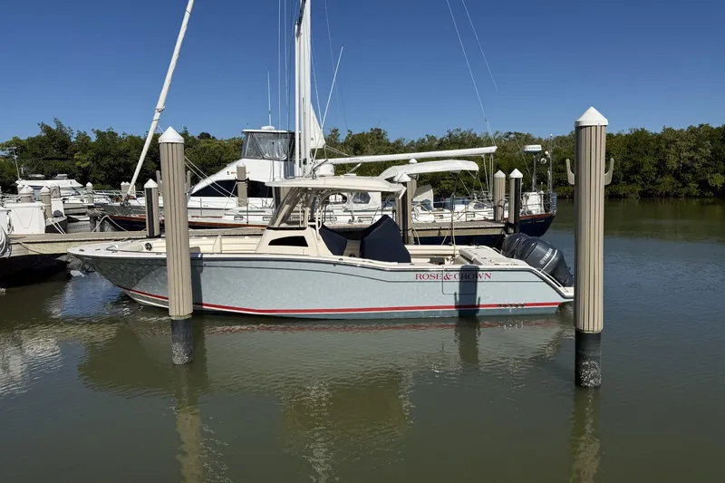Slide: The Image of 2020 Grady-White Canyon 326 boat docked in a marina under clear blue skies. - 1