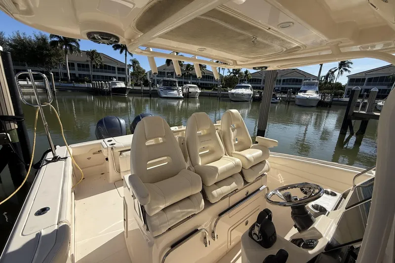 Slide: The Image of 2020 Grady-White Canyon 326 boat interior with helm and seating, docked at marina. - 12