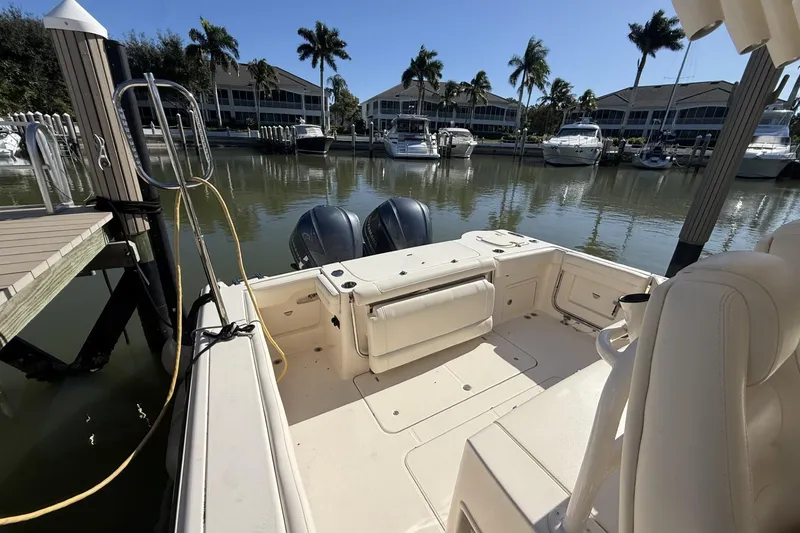 Slide: The Image of 2020 Grady-White Canyon 326 boat docked in a marina with palm trees. - 13