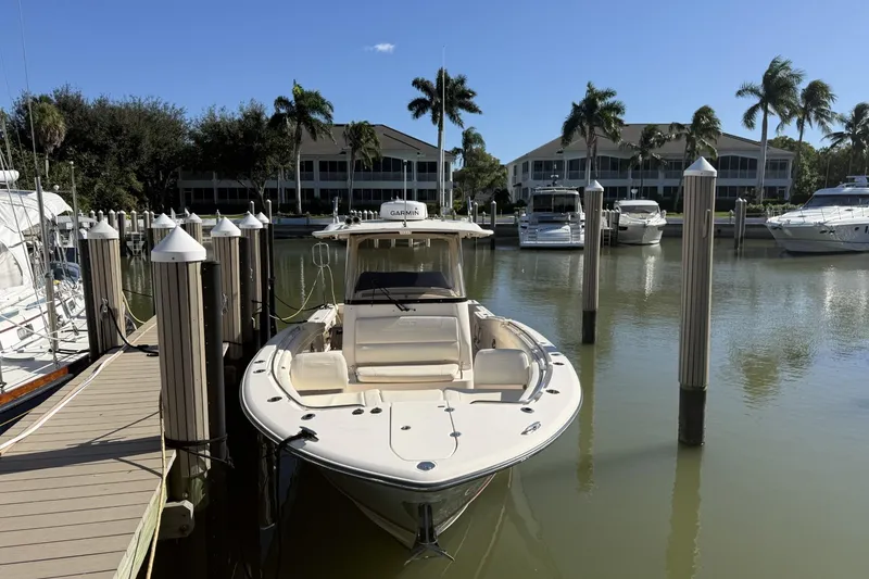 Slide: The Image of 2020 Grady-White Canyon 326 boat docked in a marina with palm trees. - 3