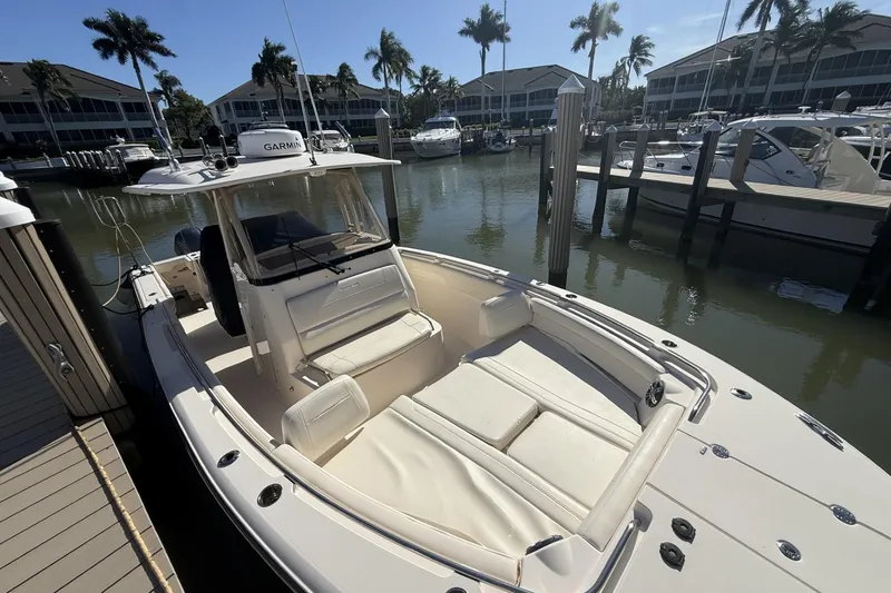 Slide: The Image of 2020 Grady-White Canyon 326 boat docked in a marina with palm trees. - 4
