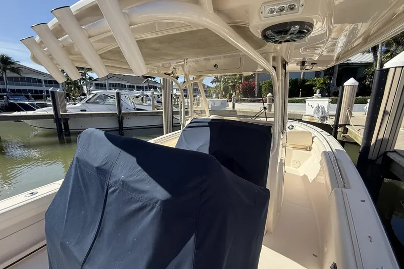 Slide: The Image of 2020 Grady-White Canyon 326 boat docked, featuring covered seating and rod holders. - 7