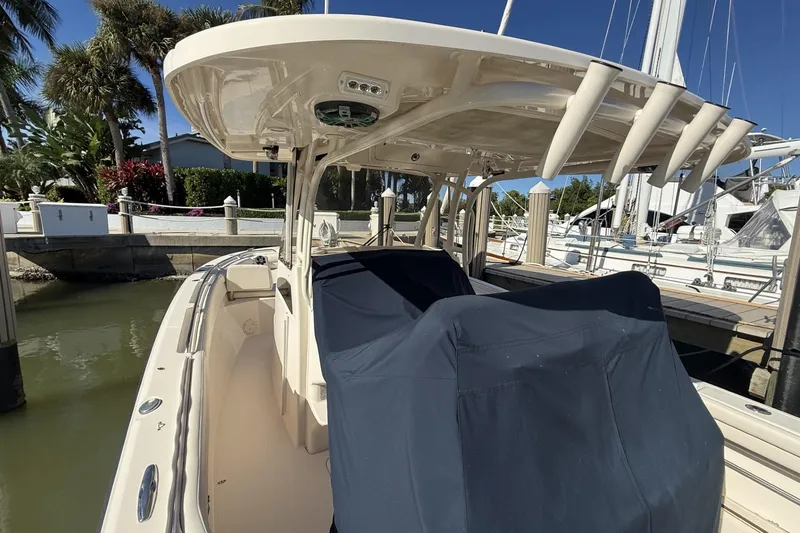 Slide: The Image of 2020 Grady-White Canyon 326 boat docked, featuring covered seating and rod holders. - 8