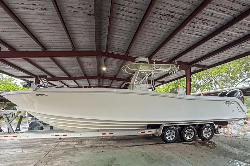 Slide: The Image of 2024 Ocean Runner 34 Center Console boat under a metal canopy on a trailer. - 3