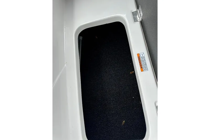 Slide: The Image of Storage compartment in 2023 Starcraft SVX 171 OB boat, featuring a carpeted interior. - 36