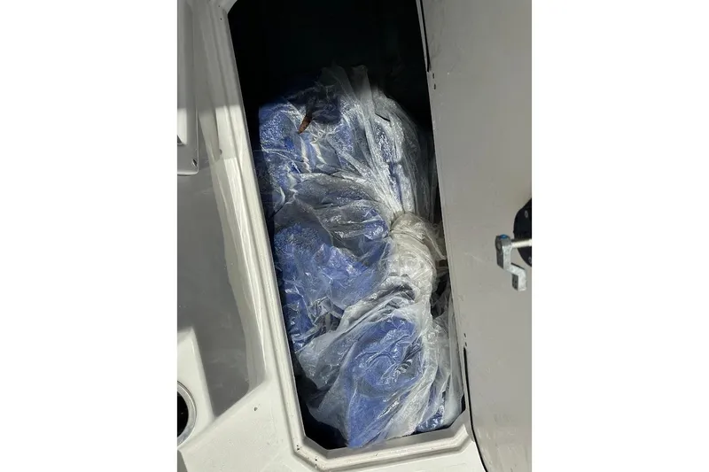Slide: The Image of 2023 Starcraft SVX 171 OB storage compartment with blue items in plastic wrap. - 38