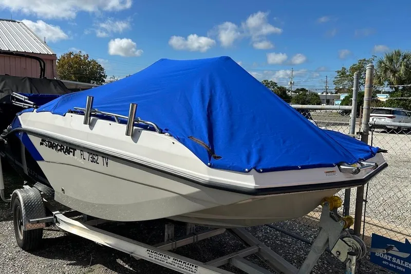 Slide: The Image of 2023 Starcraft SVX 171 OB boat with blue cover on trailer. - 42