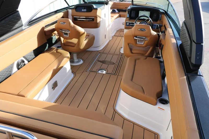 Slide: The Image of 2025 Chaparral 2870 SSX boat interior with tan leather seating and modern dashboard. - 19