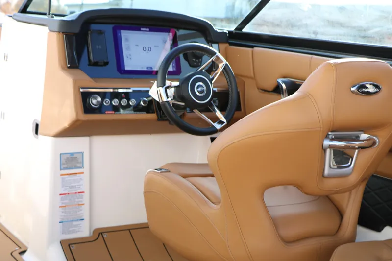 Slide: The Image of 2025 Chaparral 2870 SSX boat interior with tan leather seating and modern dashboard. - 22