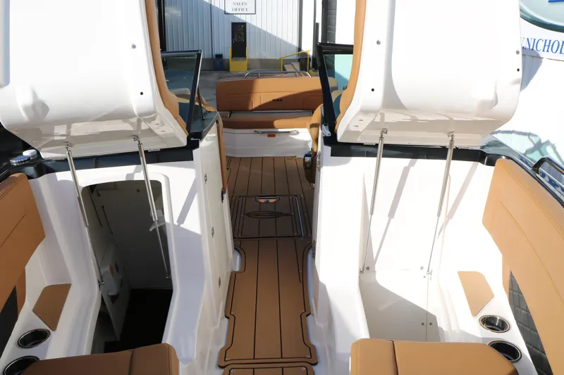 Slide: The Image of 2025 Chaparral 2870 SSX boat interior with tan seating and open compartments. - 31
