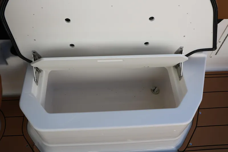 Slide: The Image of Open storage compartment on 2025 Chaparral 2870 SSX boat, featuring a white interior. - 34