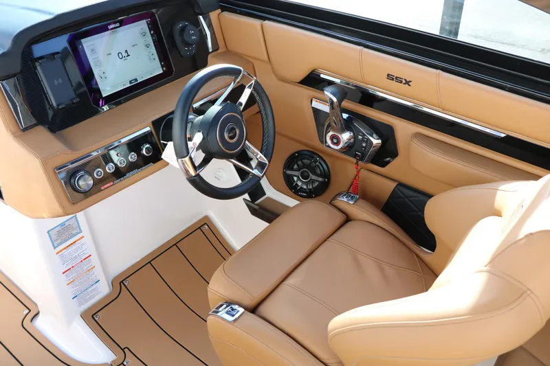 Slide: The Image of 2025 Chaparral 2870 SSX boat interior with tan leather seats and modern dashboard. - 48