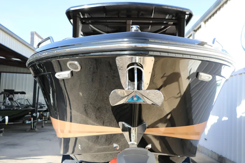 Slide: The Image of 2025 Chaparral 2870 SSX boat front view, sleek black design in a marina setting. - 7