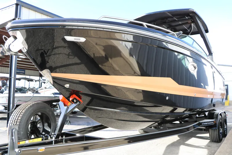 Slide: The Image of 2025 Chaparral 2870 SSX boat on trailer, sleek black design with orange accent. - 8
