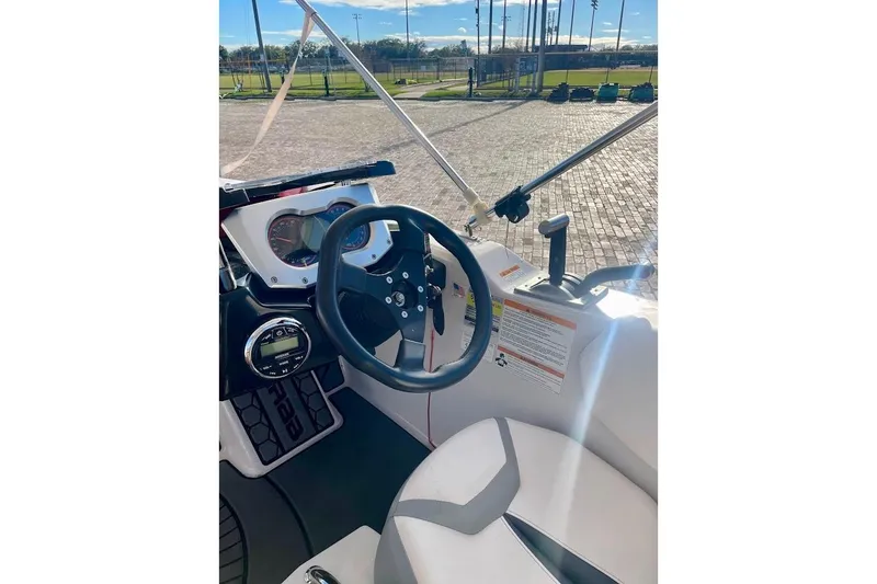 Slide: The Image of 2017 Scarab 165 HO boat cockpit with steering wheel and dashboard controls. - 10