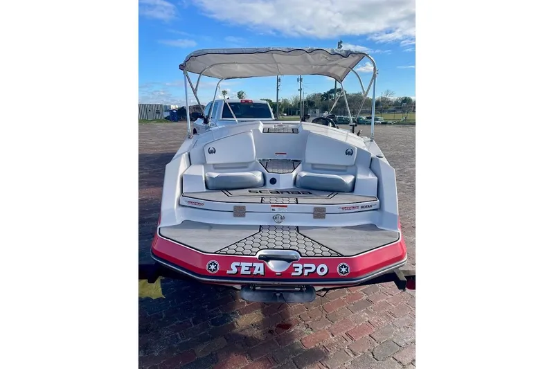 Slide: The Image of 2017 Scarab 165 HO boat with canopy, parked on brick pavement under blue sky. - 2