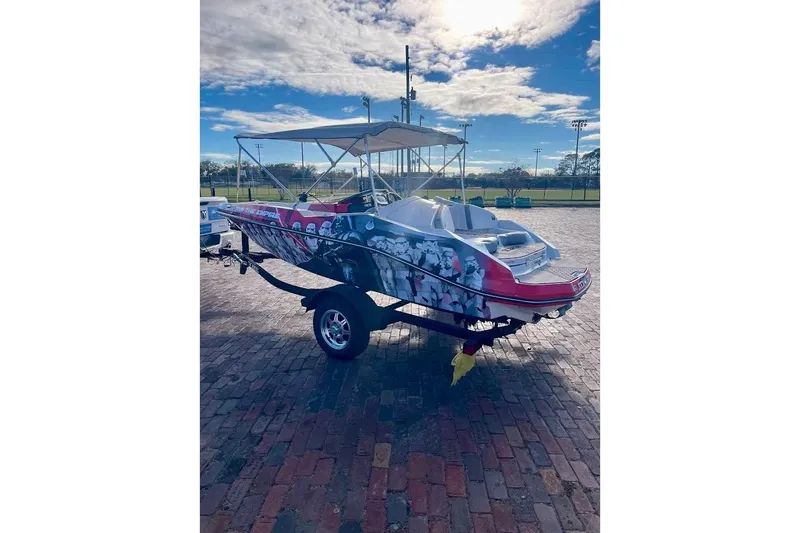 Slide: The Image of 2017 Scarab 165 HO boat with custom graphics on a trailer, parked outdoors. - 3