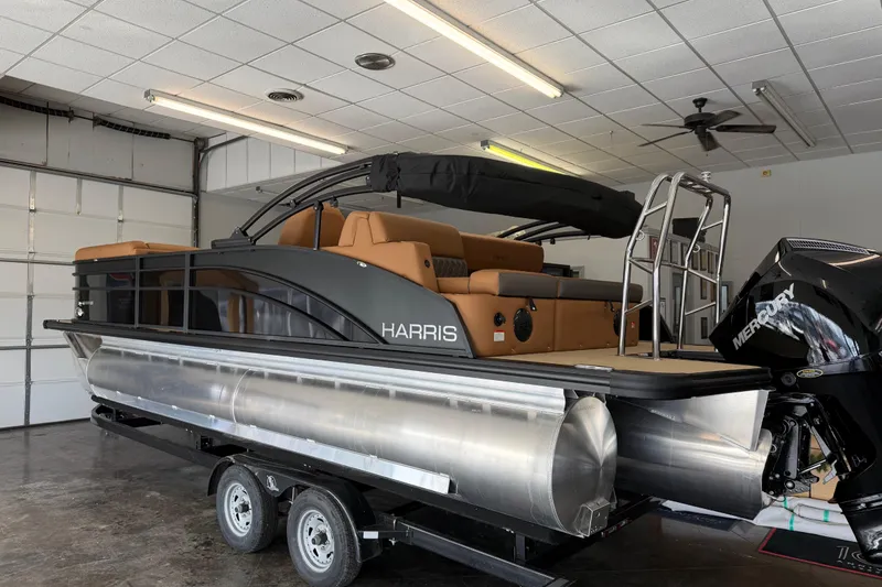 Slide: The Image of 2026 Harris Cruiser 230 pontoon boat in garage, featuring sleek design and Mercury engine. - 3