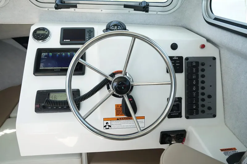 Slide: The Image of Manufacturer Provided Image: 2019 Parker 2320 Sport Cabin boat dashboard with steering wheel and navigation instruments. - 18