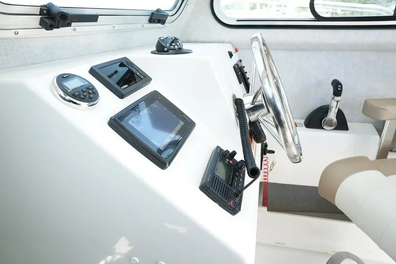 Slide: The Image of Manufacturer Provided Image: 2019 Parker 2320 Sport Cabin boat dashboard with navigation instruments and steering wheel. - 19