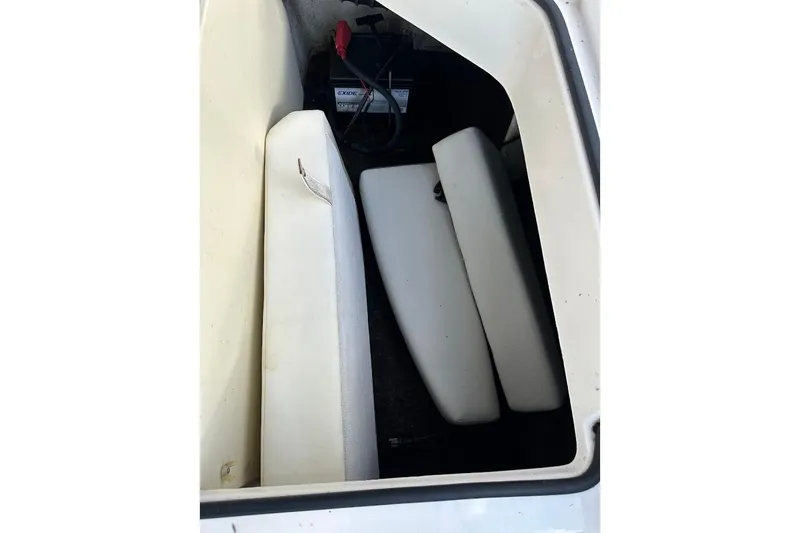 Slide: The Image of Storage compartment in a 2012 Regal 2100 Bowrider boat with battery and cushions. - 36
